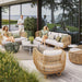 Boxhill's Nest Lounge Chair Lifestyle image at patio with other Nest Collection and 2 woman sitting down, and a man walking at the side