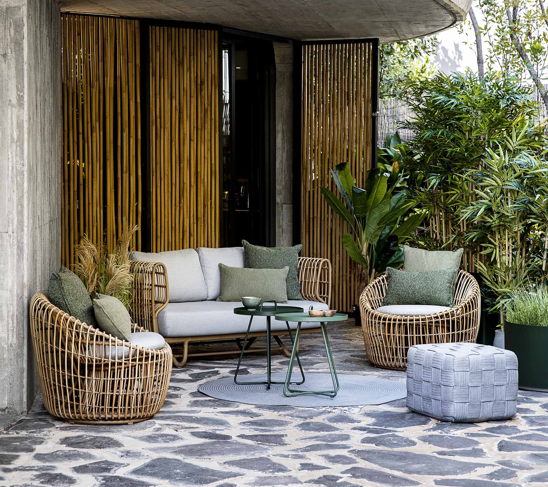Boxhill's Nest 2-Seater Sofa lifestyle image with Nest Lounge Chair and Nest Round Rattan Chair at patio