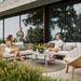 Boxhill's Nest Sofa Outdoor 3 Seater lifestyle image at patio with man and a woman sitting down having a chat, and another woman walking at the side