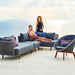 Boxhill's Moments 2-Seater Right Module Sofa lifestyle image with Moments Outdoor Corner Module and 2 women, 1 is sitting and the other 1 is standing