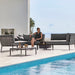 Boxhill's Conic Lounge Combo B Grey lifestyle image with Conic Coffee Table with a woman sitting down beside the pool