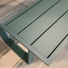 Close-up view of a green aluminum picnic bench table, focusing on the bench