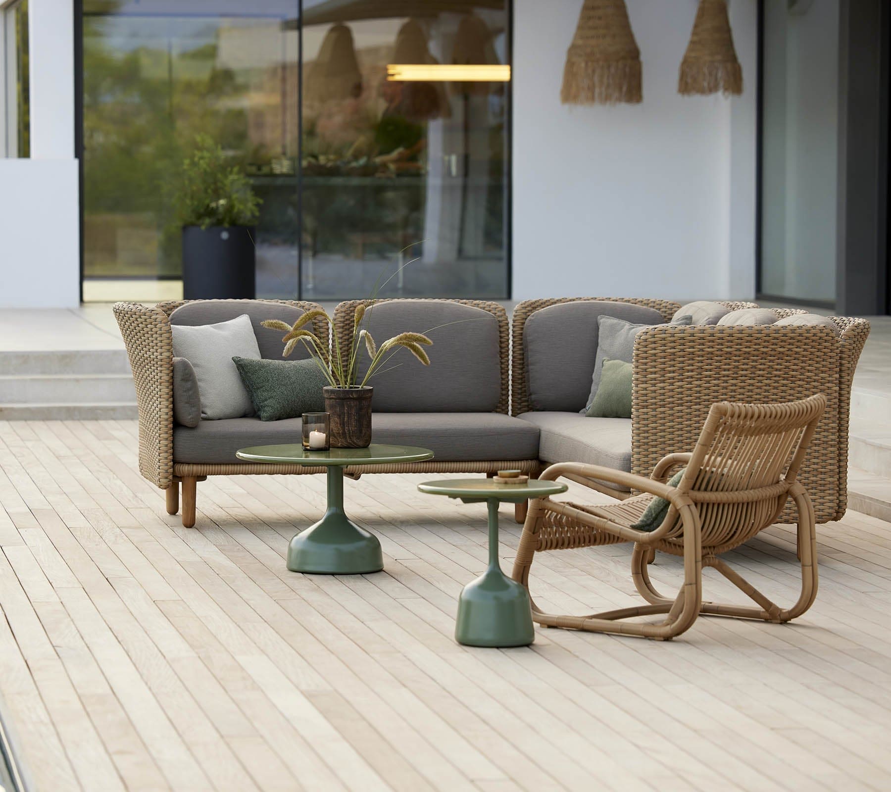 Boxhill's Glaze Outdoor Round Coffee Table lifestyle image with module sofa on wooden platform at patio 