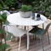 Boxhill's Area Outdoor Aluminum Dining Table White Lifestyle image on wooden platform at the garden with plant and cups on top