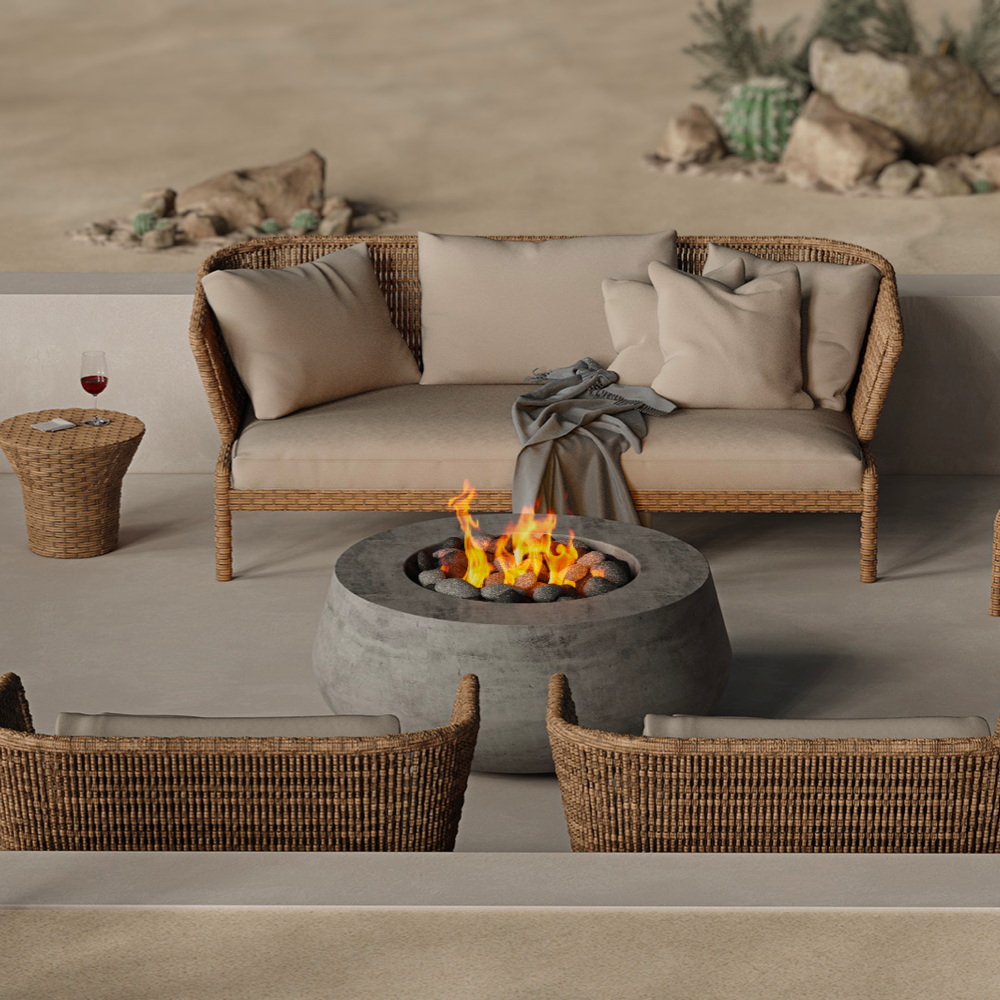 Wicker outdoor sofas with neutral cushions arranged around a modern concrete fire bowl in a desert-inspired courtyard.