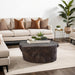 Bark Bronze Coffee Table holding a tray of plants in front of a cream sofa with warm brown pillows.
