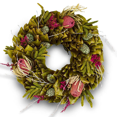 Festive  green wreath with dried flowers and textures in vibrant red-pinks and greens against pure white background.