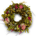 Decorative green spring wreath with magnolia leaves, dried magnolia pods, fuschia caspia, and natural textures