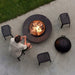 Boxhill's Cut High Outdoor Stool lifestyle image with a man sitting down and a fire pit in front, top view