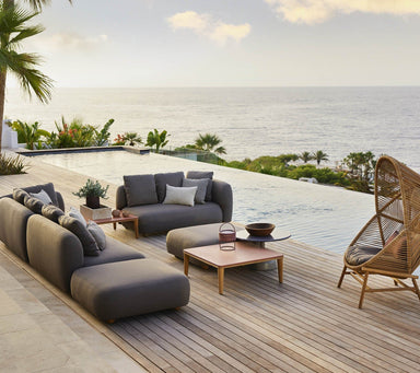Boxhill's Capture Outdoor Pouf lifestyle image with Capture Module Sofa and Capture Coffee Table beside the pool