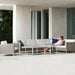 Boxhill's Connect Corner Sofa lifestyle image at patio with a woman sitting down