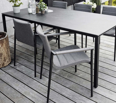 Boxhill's Core Patio Dining Armchair (Set of 2) Grey lifestyle image with a dining table on wooden platform