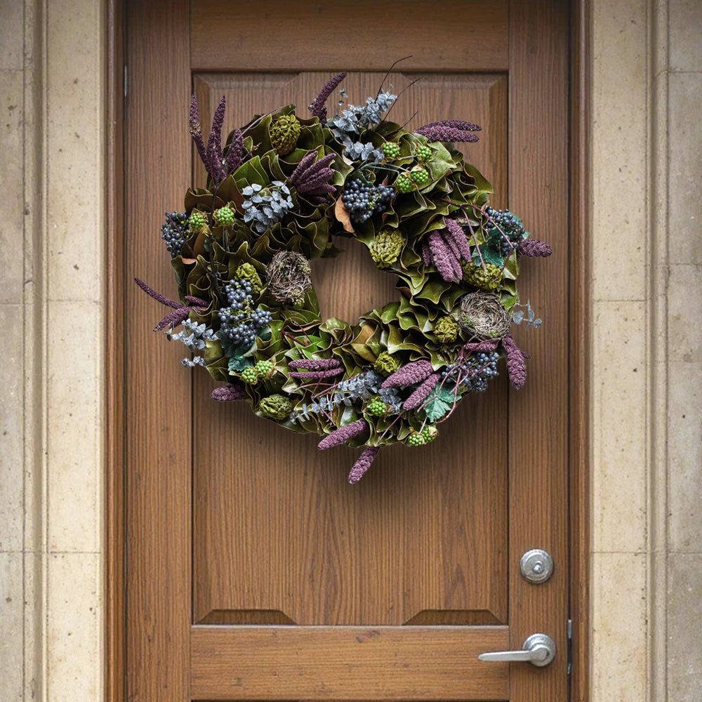 Decorative spring wreath with green leaves, purple flowers, and tiny nests hanging on a wooden front door