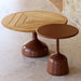 Round wooden top patio coffee table and brown round outdoor side table on a tiled floor