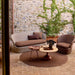 Patio setup with round wooden top coffee table, brown side table, and wicker outdoor sofa and lounge chair with brown cushions