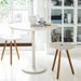 White round aluminum patio cafe table paired with two white round side chairs with wooden feet, set in a living room