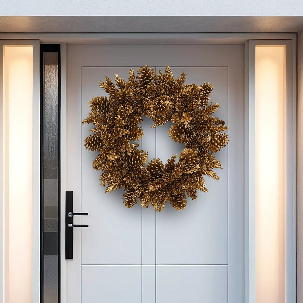 Decorative gold pinecone wreath with a radiant finish on a modern white front door.