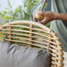 Boxhill's Hive Outdoor Highback Lounge Chair Natural Frame and Taupe Cushion close up view with a man putting a neck cushion on it