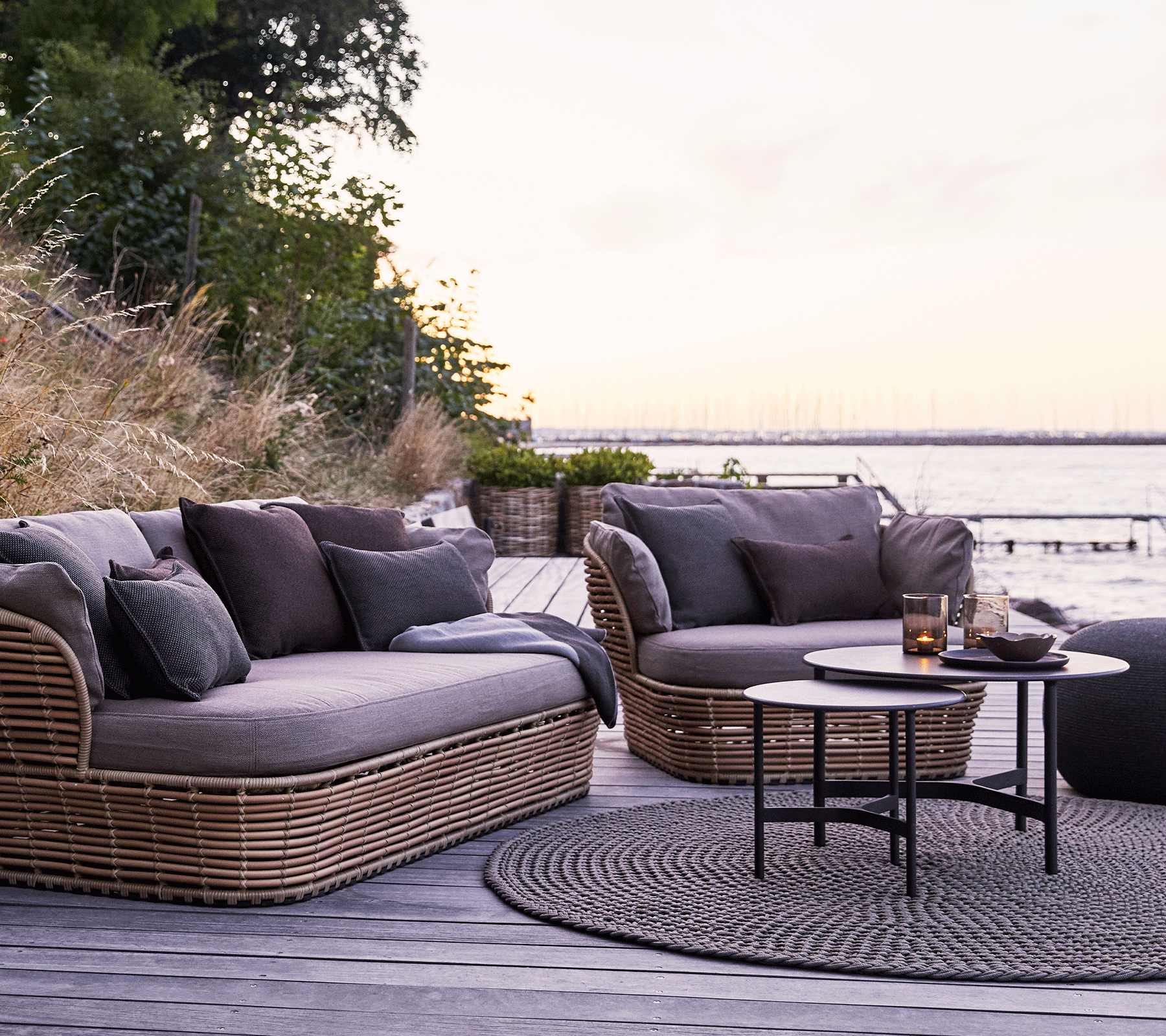 Boxhiil's Discover Round Outdoor Rug Taupe lifestyle image with 3-seater sofa, lounge chair and round table at the center
