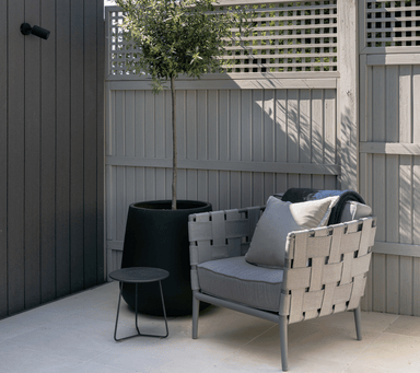 Boxhill's Conic Lounge Chair Light Grey lifestyle image at patio beside a plant