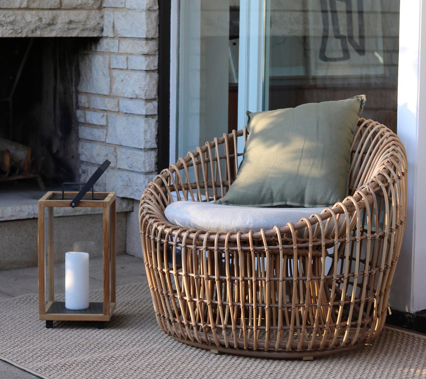 Boxhill's Nest Round Rattan Chair lifestyle image with Lighthouse Outdoor Large Teak Lantern at patio