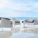 Boxhill's Kingston Stackable Outdoor 2-Seater Sofa lifestyle image with Kingston Outdoor Stackable Lounge Chair and white round table at seafront
