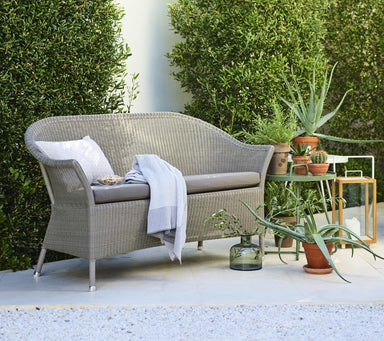 Boxhill's Lansing Outdoor 2-Seater Sofa Taupe lifestyle image at patio with pillow and fabric on top