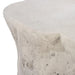 A close-up of a textured stone or concrete outdoor coffee table with a rough, organic surface and a light gray finish, isolated on a white background.