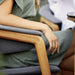 Boxhill's Luna Outdoor Dining Armchair Lifestyle image with a woman sitting down, close up view