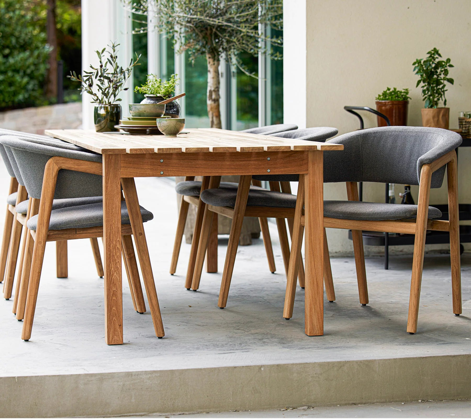 Boxhill's Luna Outdoor Dining Armchair Lifestyle image with teak dining table at patio