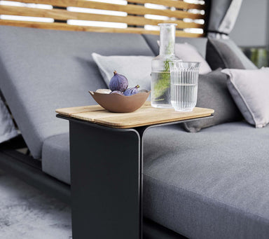 Boxhill's Mega Outdoor Side Table lifestyle image beside the bed with a glass of water, bottle container and a bowl of fruits on top