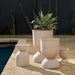 Set of beige outdoor planters with a cactus in the background