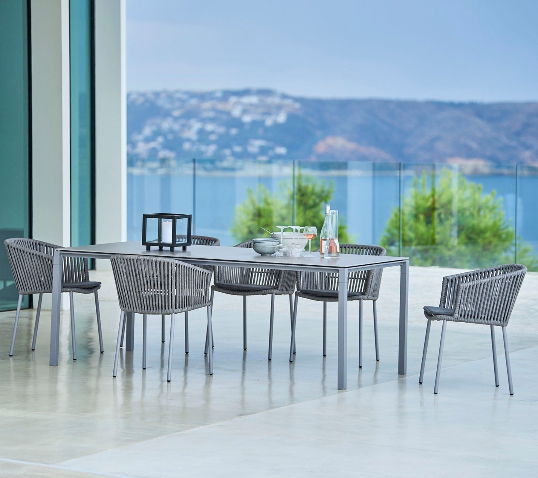 Boxhill's Moments Stackable Arm Chair lifestyle image with dining table at patio