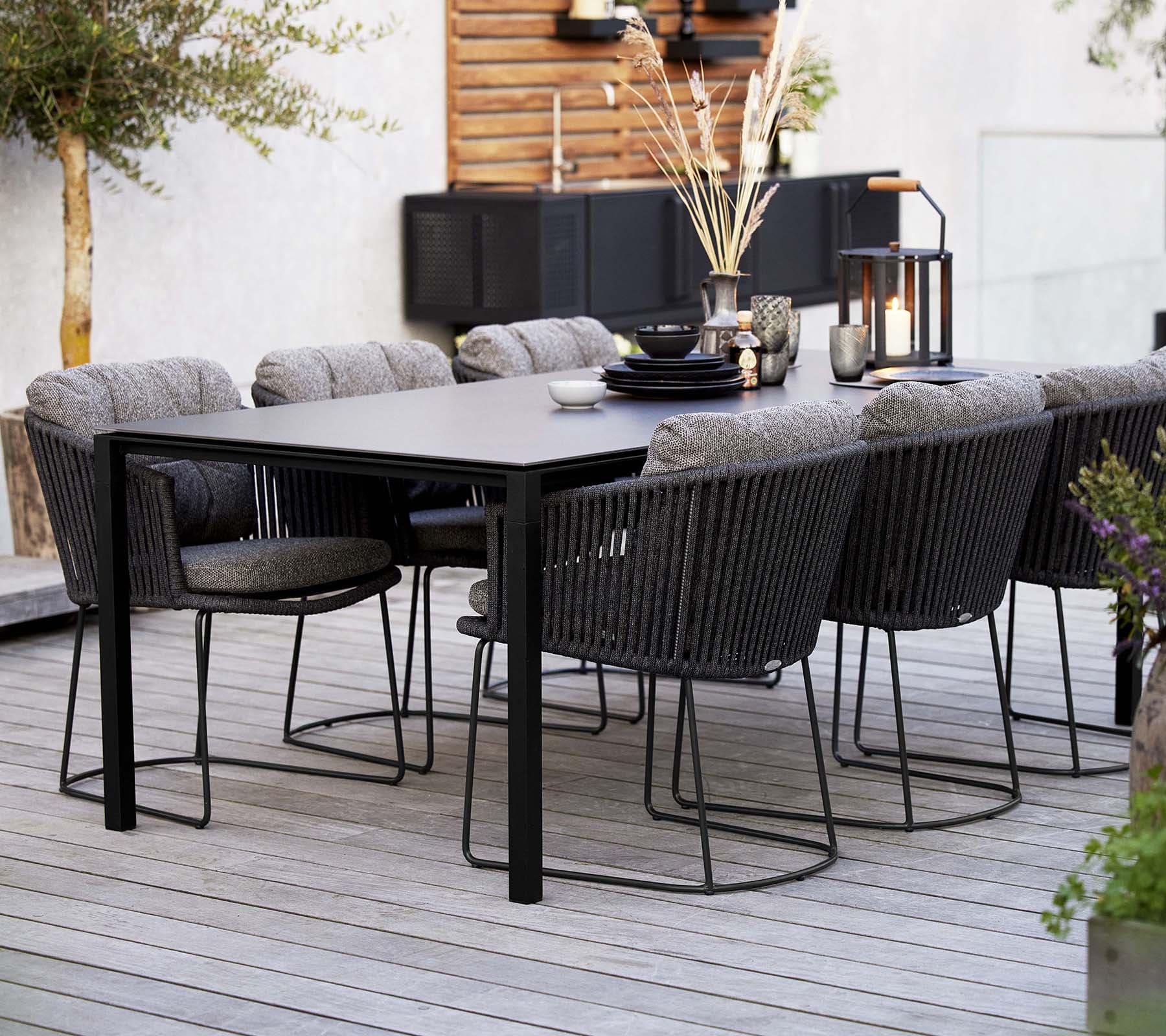 Boxhill's Moments Outdoor Dining Armchair lifestyle image with dining table at patio