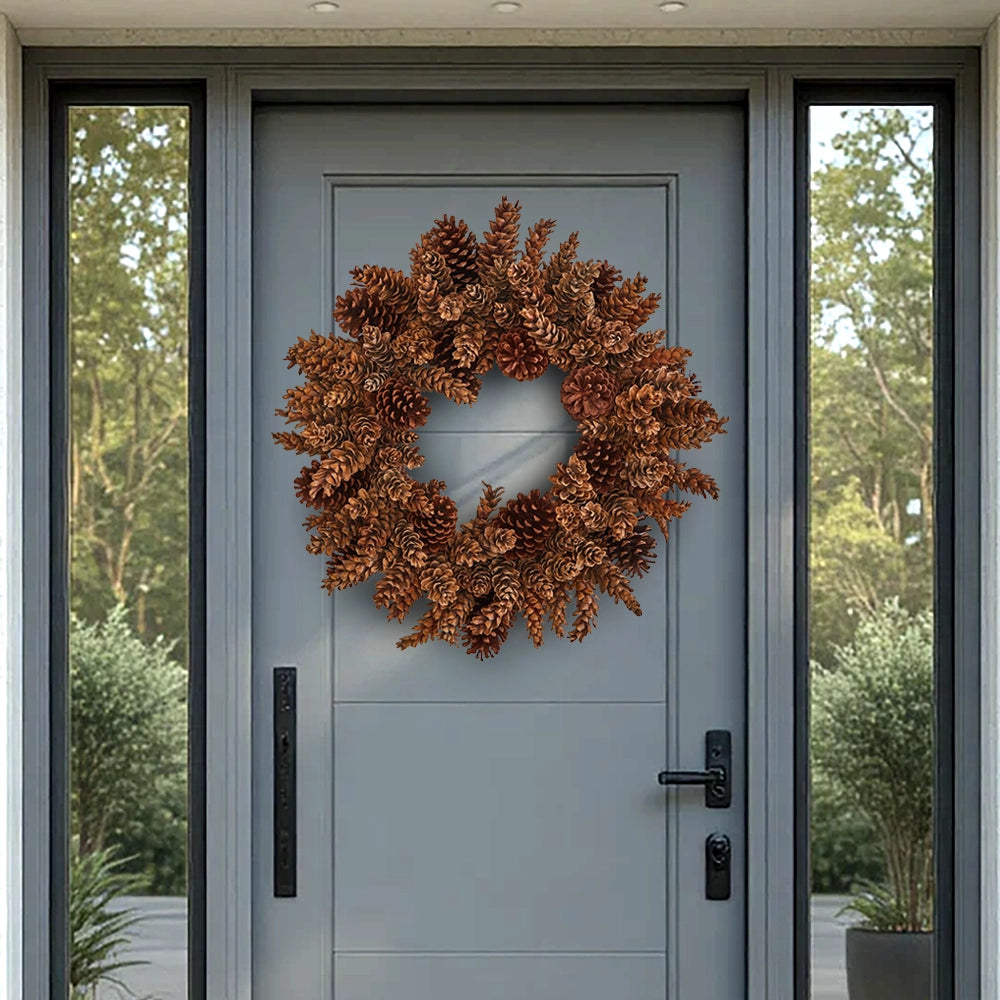 Brown natural pinecone wreath on a gray front door with side glass panels.