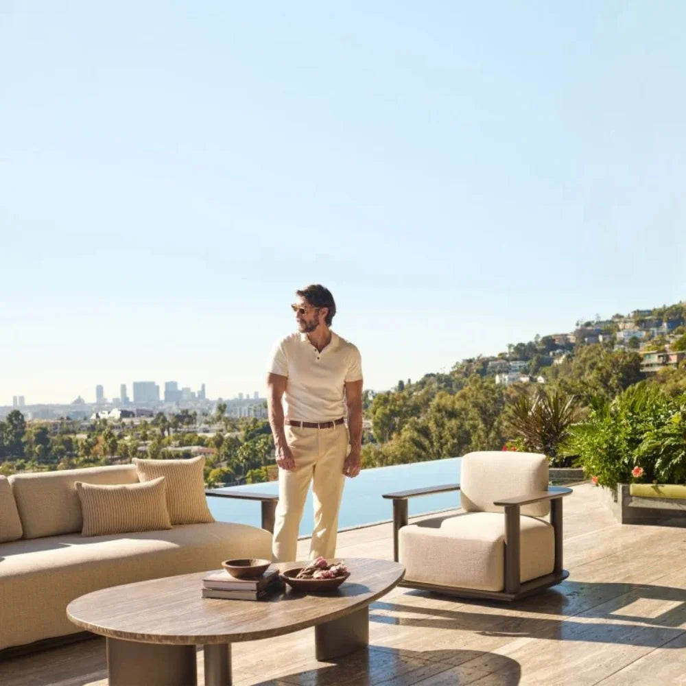 A contemporary beige aluminum outdoor barrel lounge chairs, matching the urban scenery.