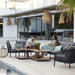 Boxhill's Ocean Large Outdoor 2-Seater Sofa lifestyle image beside the pool with other Ocean Sofa and Chair Collection , Level Coffee Table with Teak Top and 2 people sitting down
