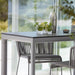 Boxhill's Drop Outdoor Bar Table lifestyle image with Breeze Bar Stackable Chair and 3 glass of cocktail with lemon and cocktail shaker on top