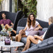   Boxhill's Peacock dark grey outdoor wing 3-seater sofa with 2 women sitting on it and a man sitting on outdoor highback chair