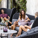  Boxhill's Peacock dark grey outdoor wing highback chair with a man sitting on it and 2 women sitting on dark grey outdoor sofa