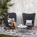  Boxhill's Peacock dark grey outdoor wing highback chair with a woman sitting on it reading a book and light grey coffee table