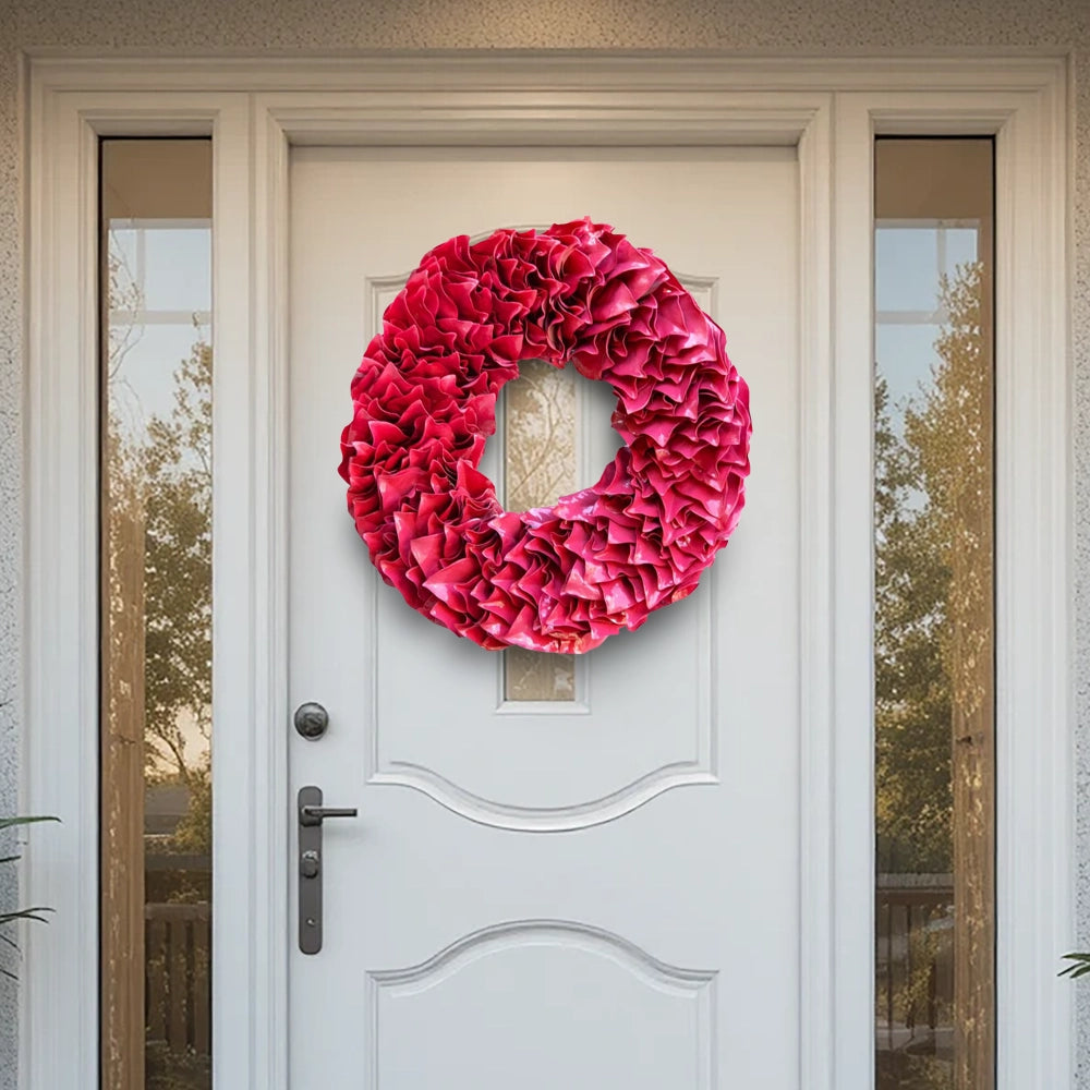 Decorative bright red-pink lacquer wreath on a white front door with glass panels.