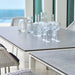 Boxhill's Pure white aluminum outdoor dining table with grey table top with glasses and bottles on it