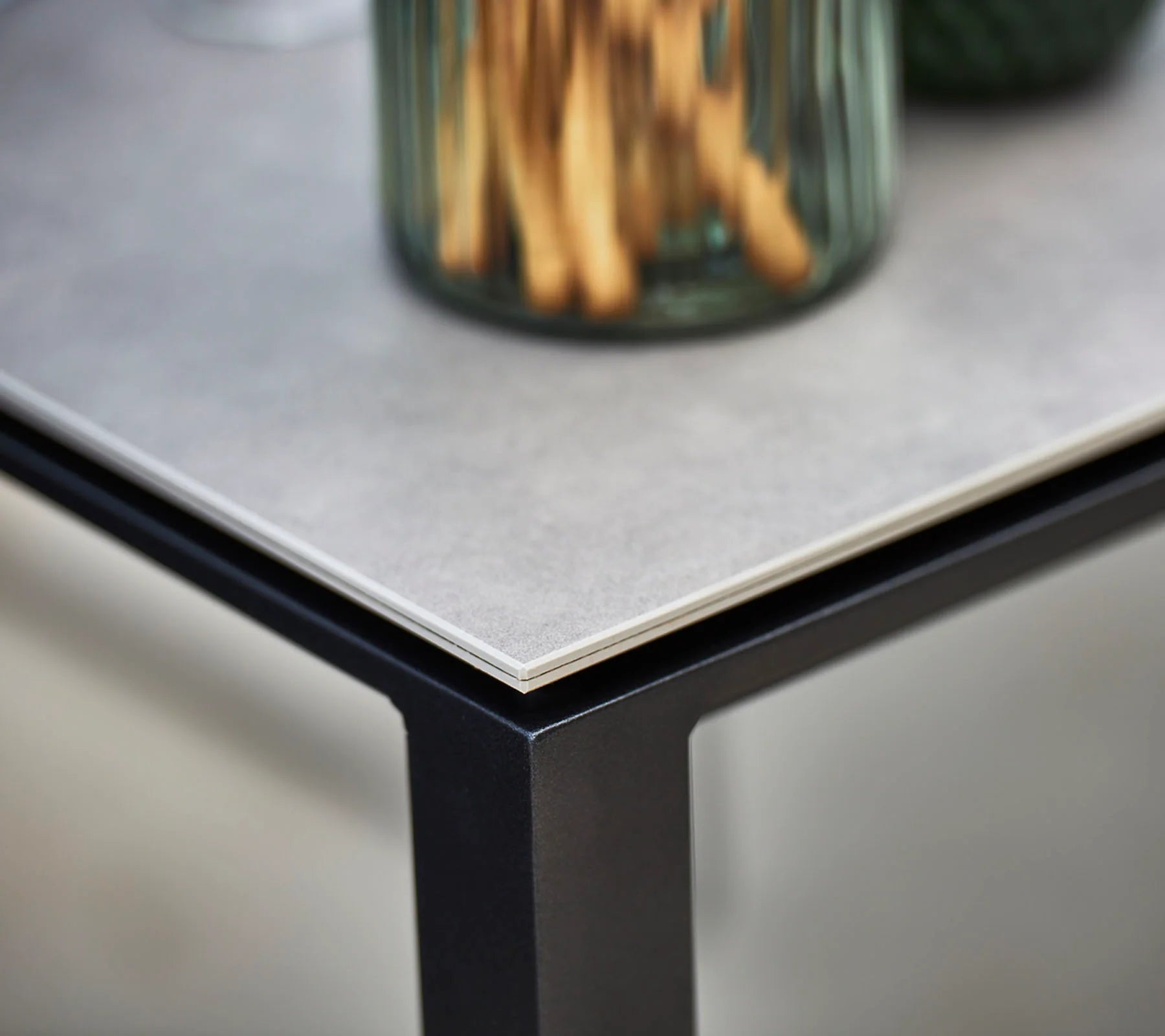Boxhill's Pure dark grey aluminum outdoor dining table with light grey table top close up view