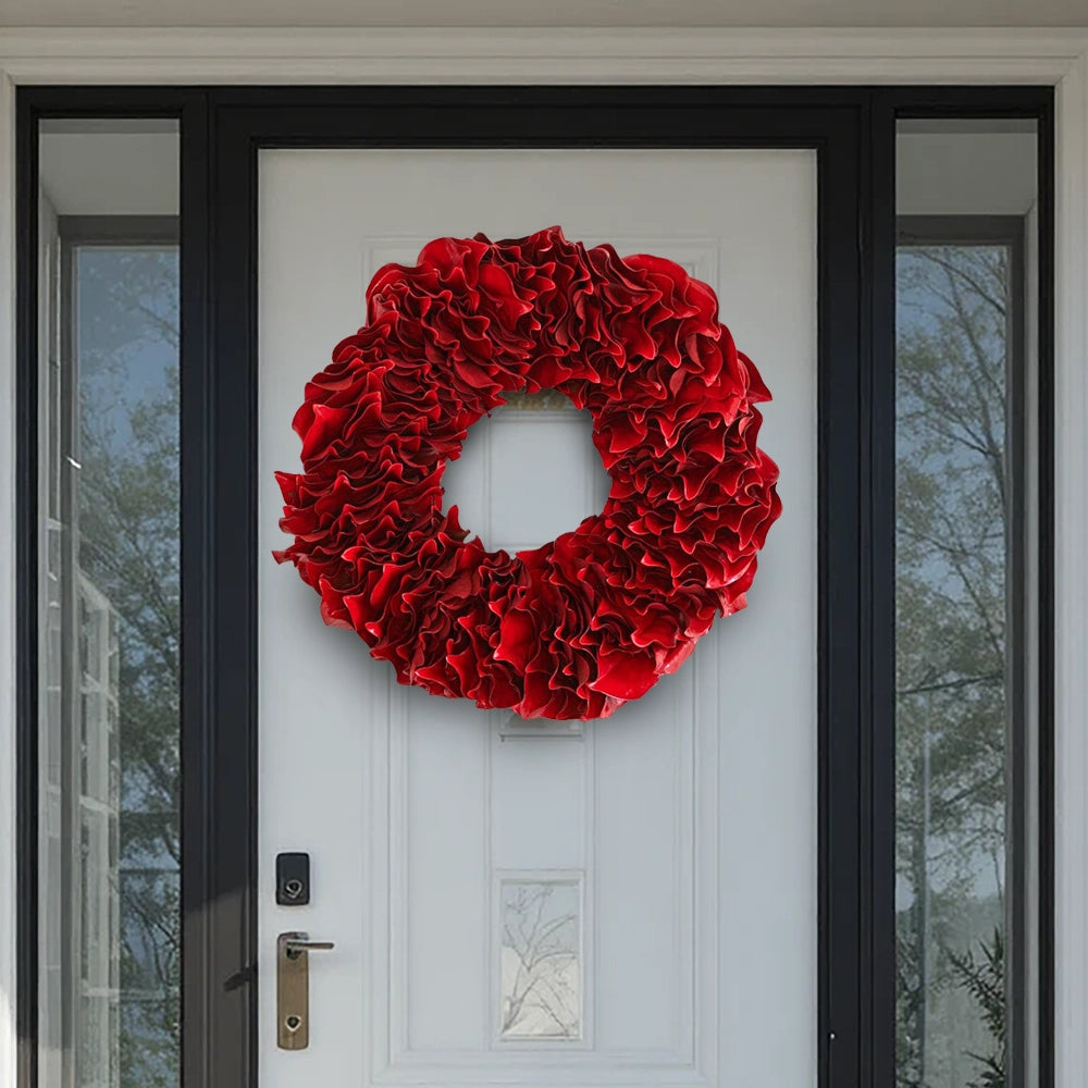 Decorative red lacquer wreath on a modern front door with black frame and glass side panels.
