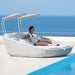 Boxhill's Savannah white grey outdoor sectional chaise lounge with shade with a woman sitting on it placed on poolside