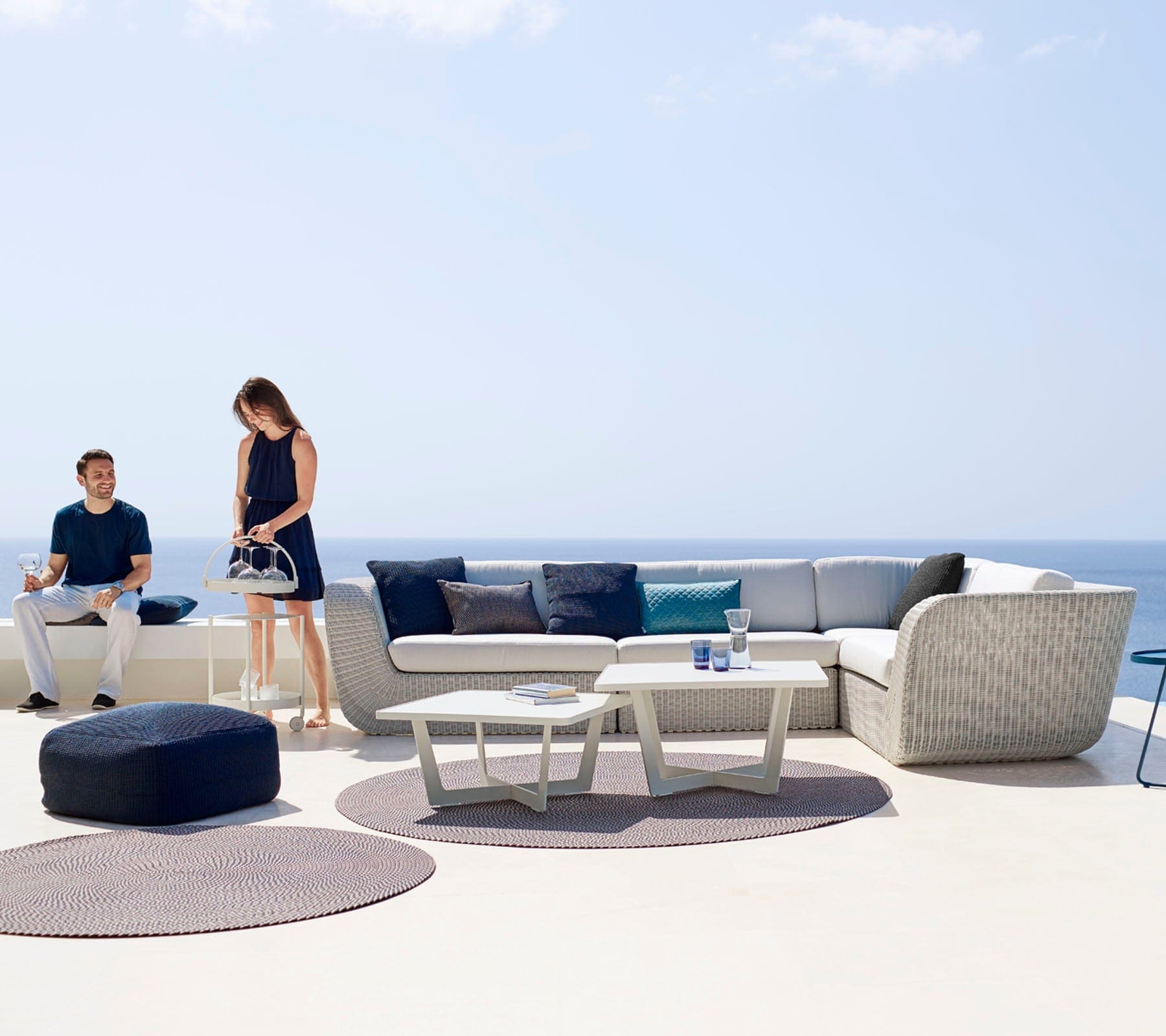   Boxhill's Savannah white grey outdoor sectional sofa with white cushion with 2 white table and dark blue footstool set at seafront