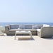 Boxhill's Savannah white grey outdoor sectional sofa with white cushion and a white table set at seafront