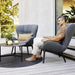 Boxhill's Serene grey outdoor lounge chair with man sitting on it and grey outdoor round table placed on dark grey round rag