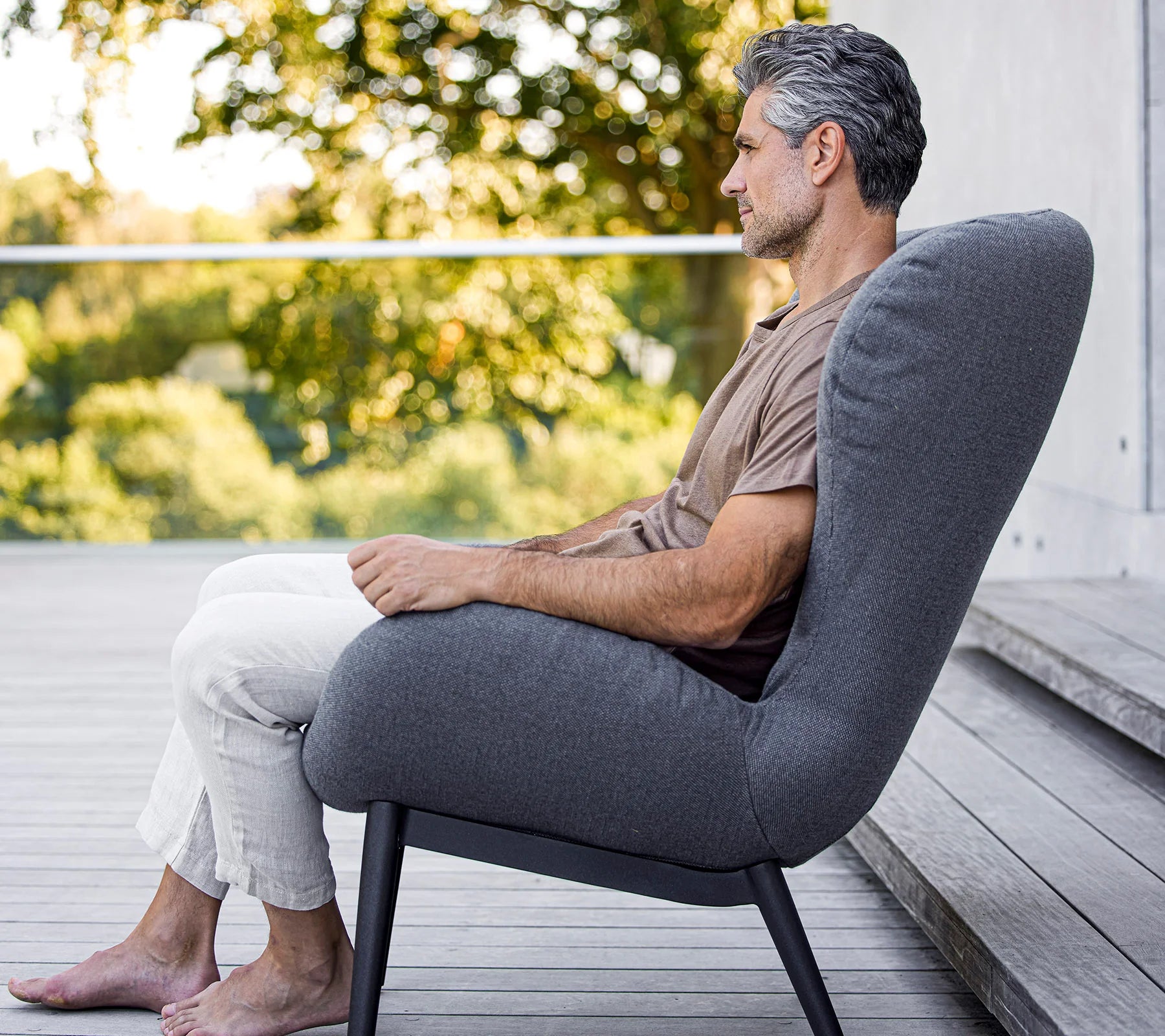 Boxhill's Serene grey outdoor lounge chair with a man on brown shirt sitting on it